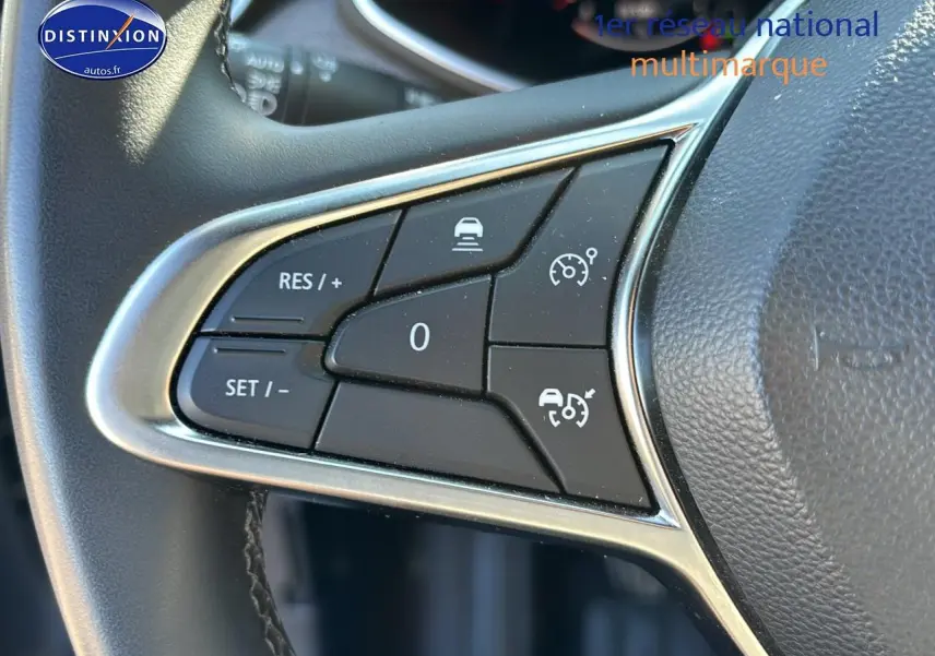 Gros plan sur les commandes au volant textile grainé de la Renault Clio V 1.0 TCe 90 Techno 2024.