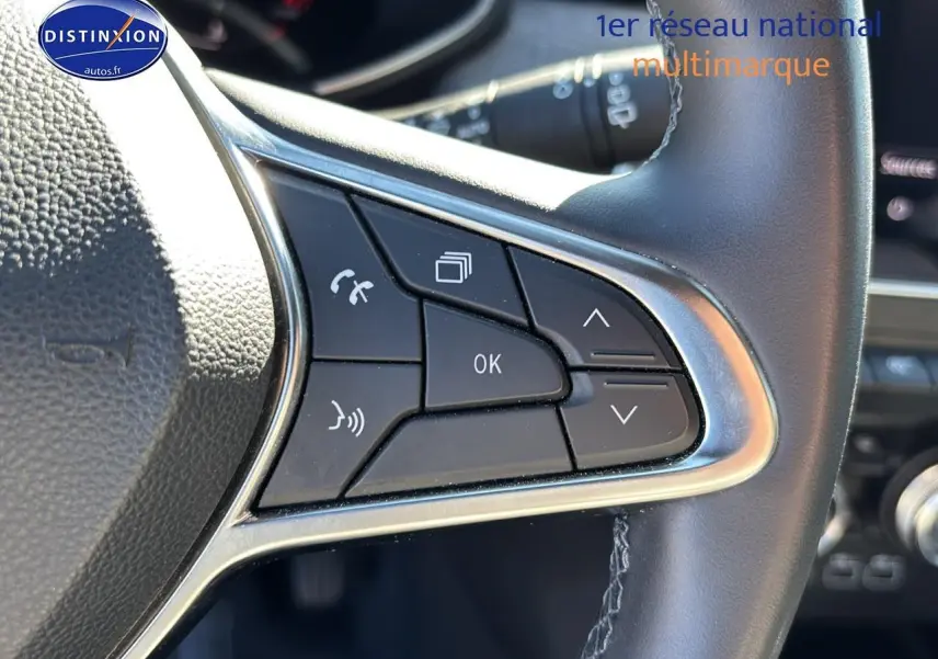 Gros plan sur les commandes multifonctions du volant textile enduit gris de la Renault Clio V gris pizzara 2024