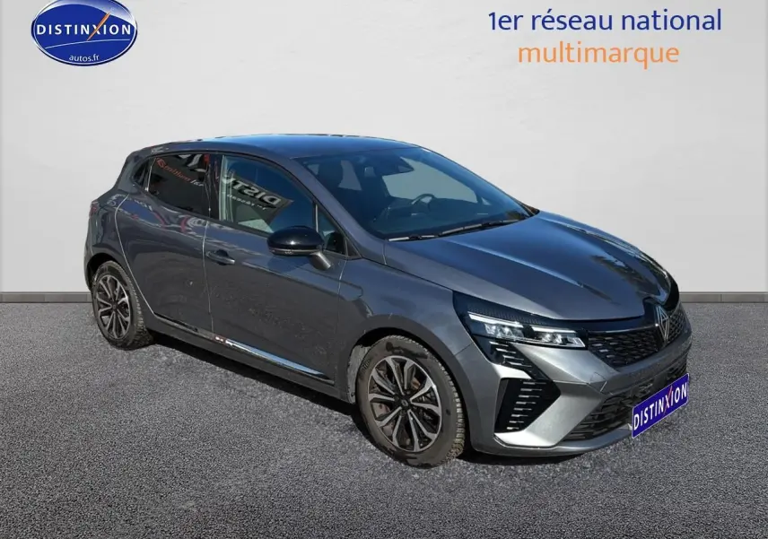 Renault Clio V gris pizzara vue 3/4 avant droit, calandre chromée et jantes alliage noires distinctives.