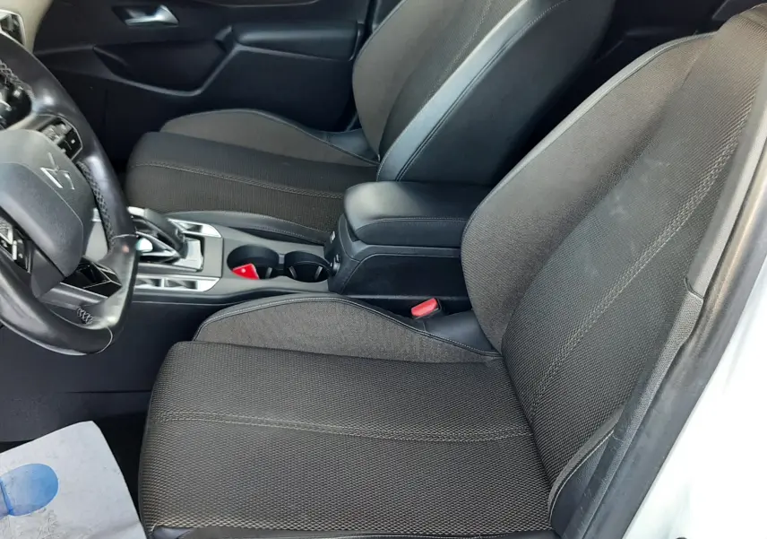 Vue intérieure côté conducteur du DS3 Crossback 2019 avec sièges tissu noir et console centrale entre les sièges.