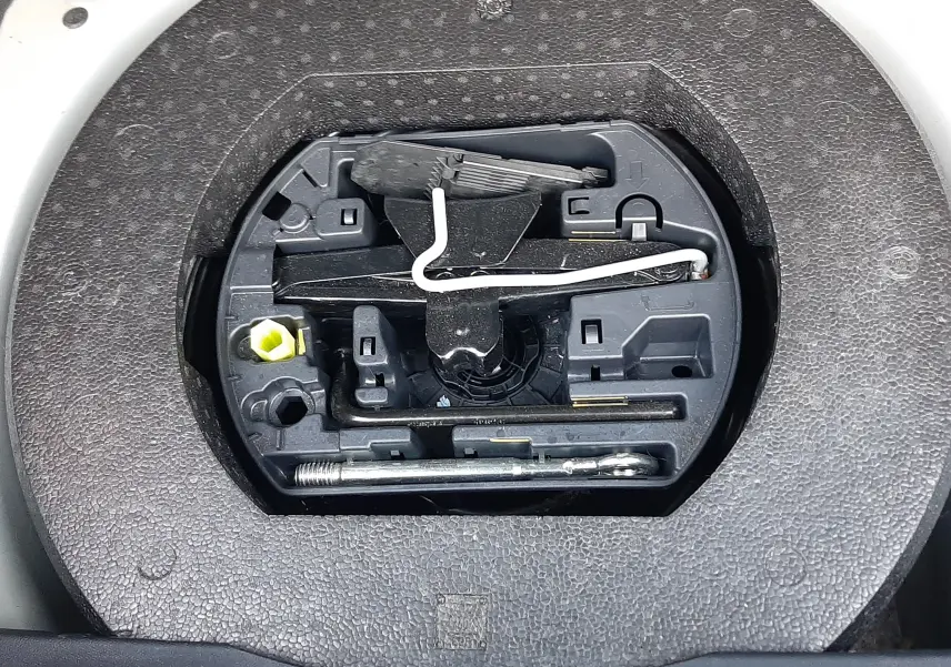 Gros plan sur le compartiment à outils du coffre du DS3 Crossback blanc perle avec toit noir, version 2019 essence.