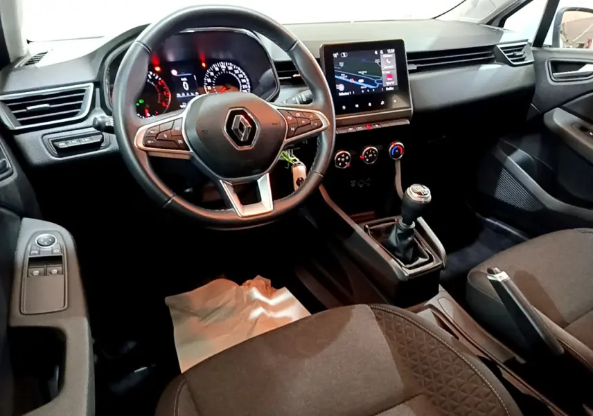 Vue intérieure avant droite du tableau de bord et volant cuir de la Renault Clio Business TCe 90 2021 avec écran tactile et boîte manuelle.