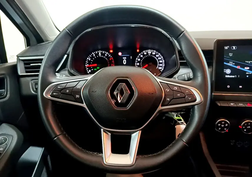 Vue frontale du volant cuir noir de la Renault Clio Business TCe 90 2021 avec tableau de bord et écran tactile visible.