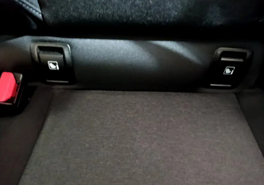Détail de la banquette arrière noire de la Renault Clio Business TCe 90 avec boutons de rabattement des sièges visibles