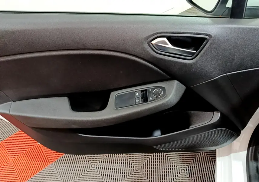 Intérieur côté gauche de la porte avant d'une Renault Clio Business blanche, avec commandes électriques des vitres et poignée noire.