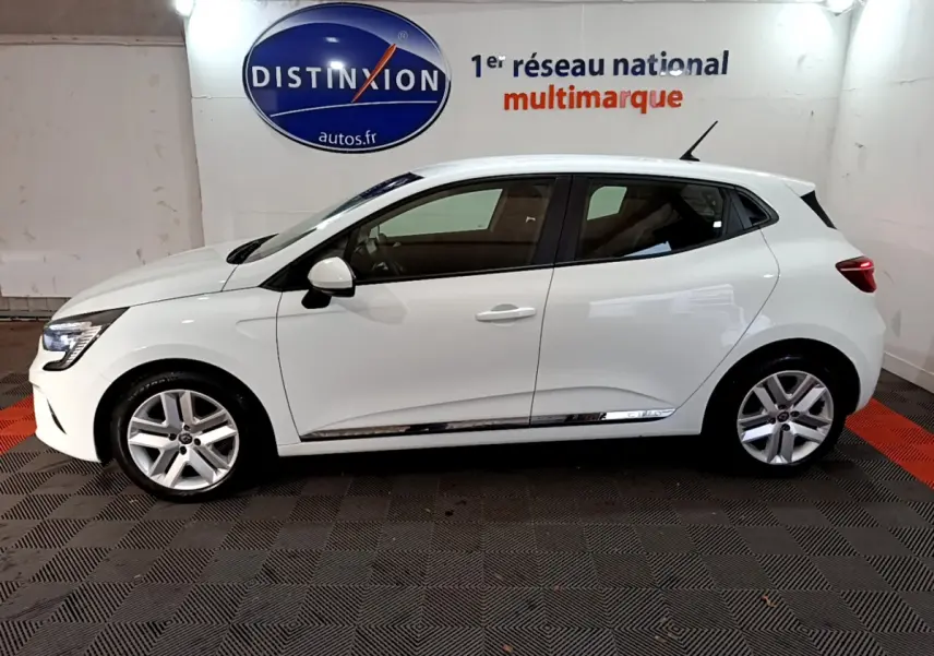 Profil côté gauche d'une Renault Clio Business TCe 90 blanche 2021, avec jantes alliage et vitres teintées, en intérieur showroom.