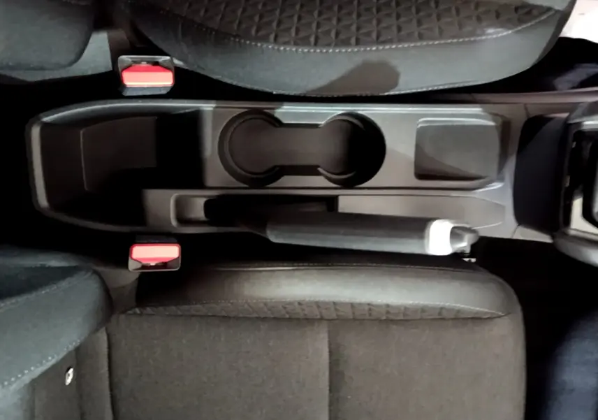 Vue plongeante sur la console centrale noire de la Renault Clio Business TCe 90 avec frein à main manuel et sièges tissu.