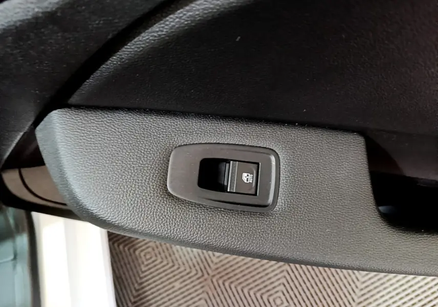 Gros plan sur le bouton de verrouillage électrique de la porte côté conducteur d'une Renault Clio blanche 2021.