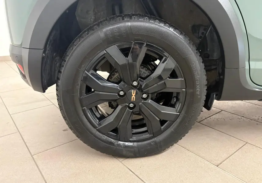 Gros plan sur la roue arrière droite noire brillante du Dacia Sandero Stepway Vert Cèdre avec attelage visible.