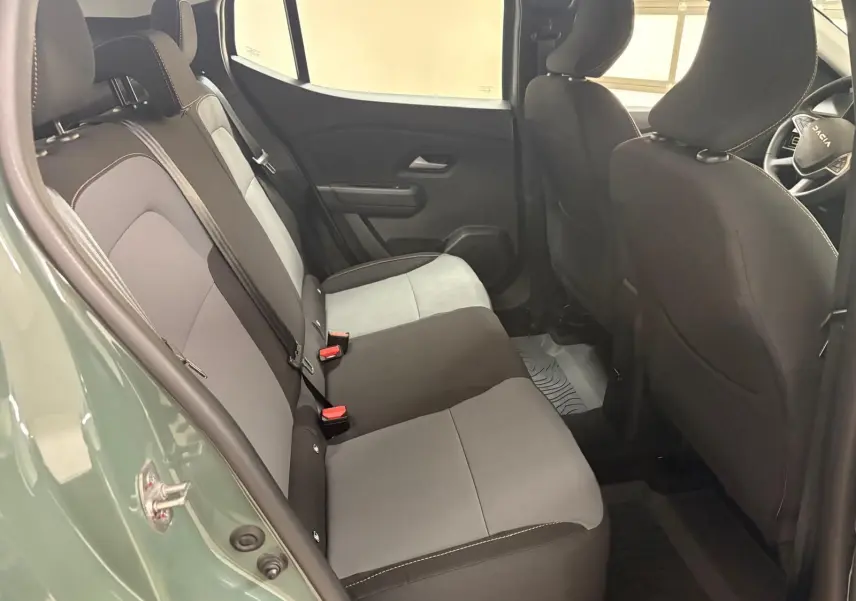 Vue intérieure côté gauche montrant la banquette arrière grise et noire du Dacia Sandero Stepway Vert Cèdre 2023.