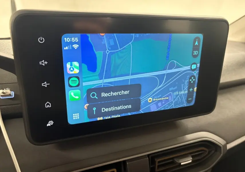 Vue avant droite du Dacia Sandero Stepway 2023 vert cèdre avec attelage, sous un éclairage naturel.