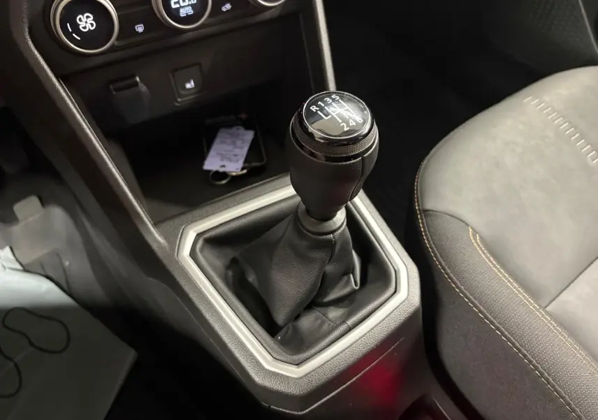 Gros plan sur le levier de vitesses manuel de la Dacia Sandero Stepway 2023, avec console centrale et siège côté droit visibles.