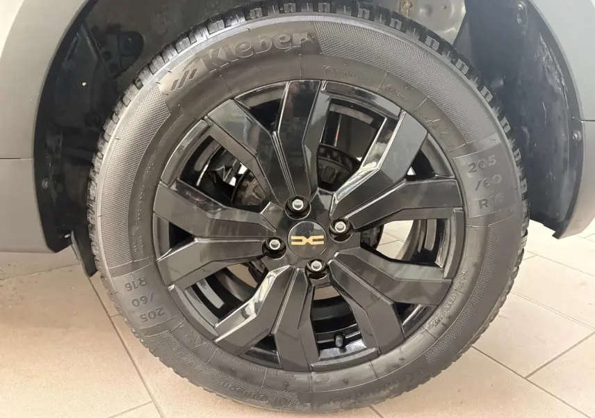 Gros plan sur la roue avant droite noire brillante du Dacia Sandero Stepway Vert Cèdre 2023 avec logo central doré.