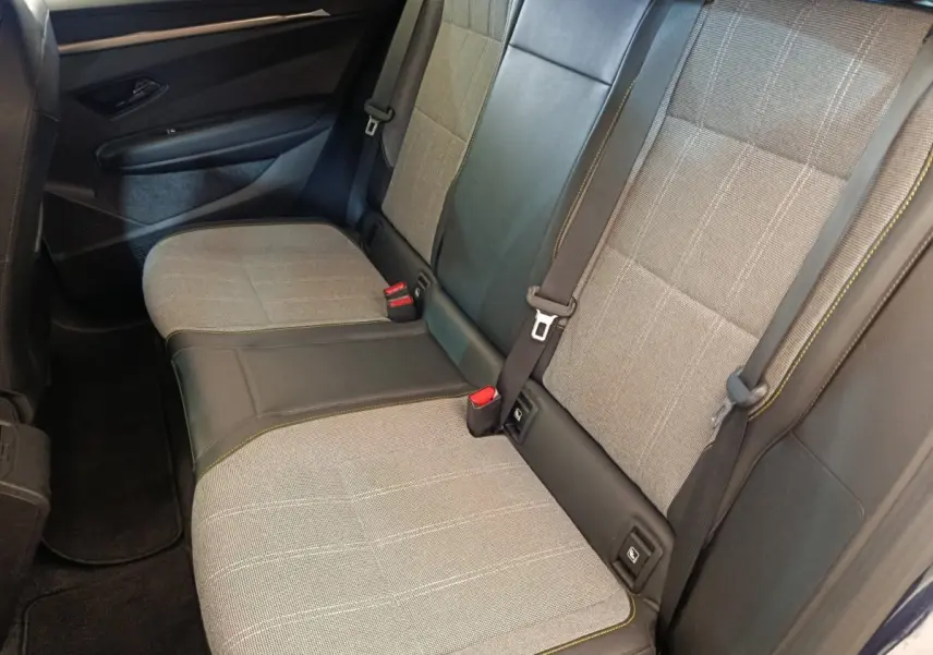 Vue latérale intérieure montrant la banquette arrière grise et noire avec ceintures et détails de la Renault Megane 2023.