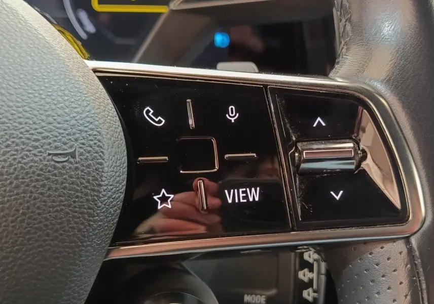 Gros plan sur les commandes tactiles noires du volant cuir de la Renault Mégane électrique 2023.