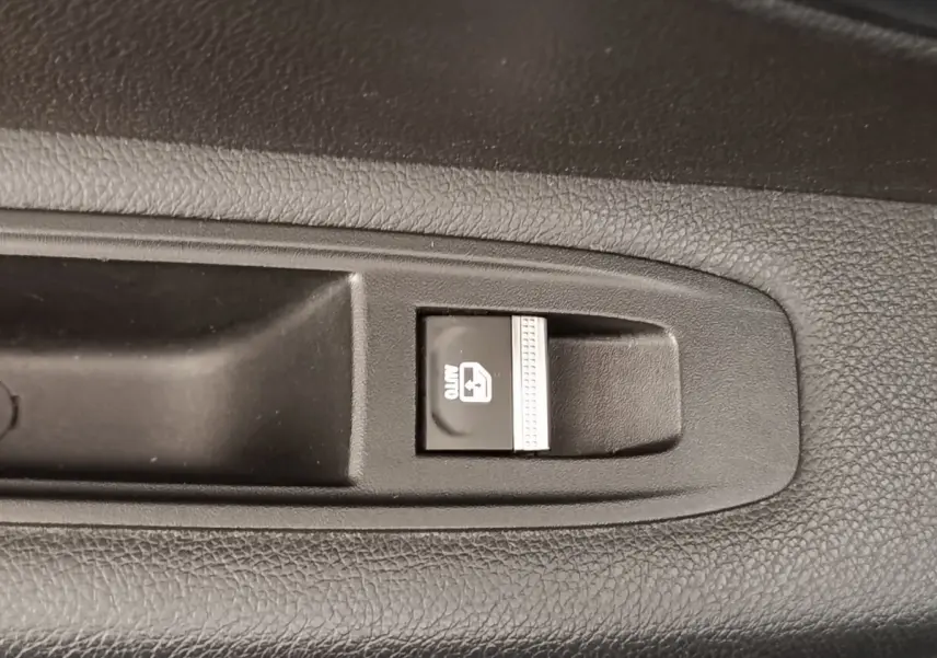 Gros plan sur le bouton de verrouillage des vitres arrière dans l'habitacle noir d'une Renault Mégane électrique 2023.