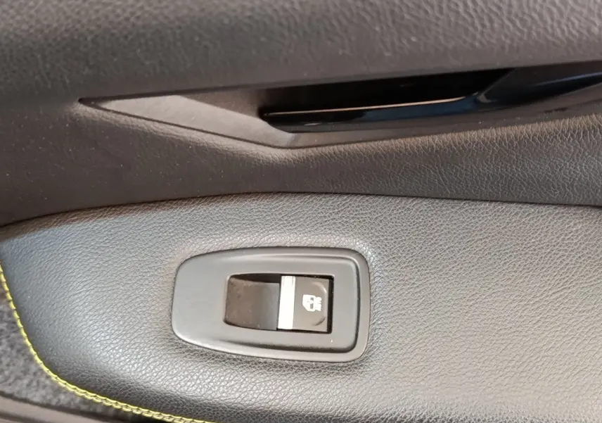 Bouton de verrouillage des portes en gros plan sur la porte intérieure noire de la Renault Mégane électrique bleu 2023.