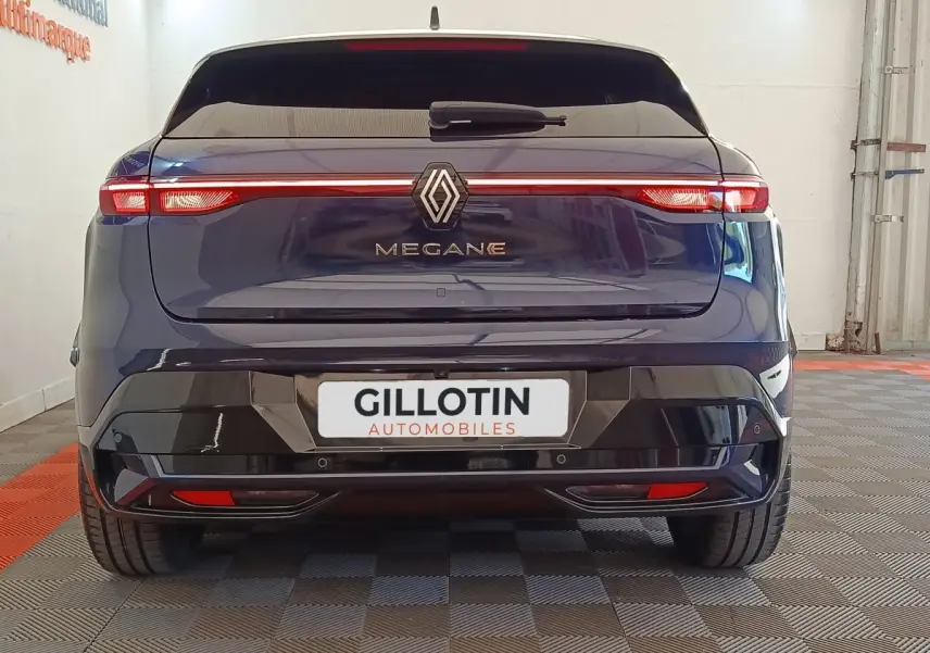 Vue arrière d'une Renault Mégane Techno EV60 bleu électrique avec feux arrière LED en bandeau lumineux.
