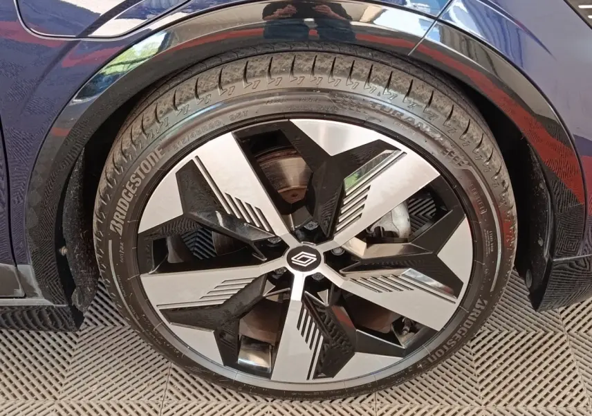 Gros plan sur la roue avant droite de la Renault Mégane Techno EV60 bleu, avec jante alliage au design moderne.