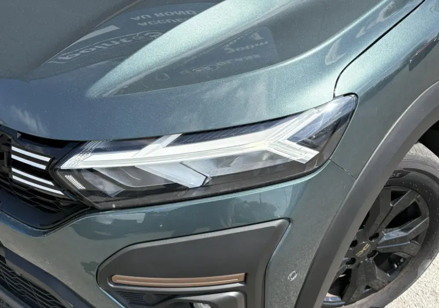 Gros plan sur l'avant droit vert cèdre du Dacia Sandero Stepway 2025 avec phares LED et jante noire.