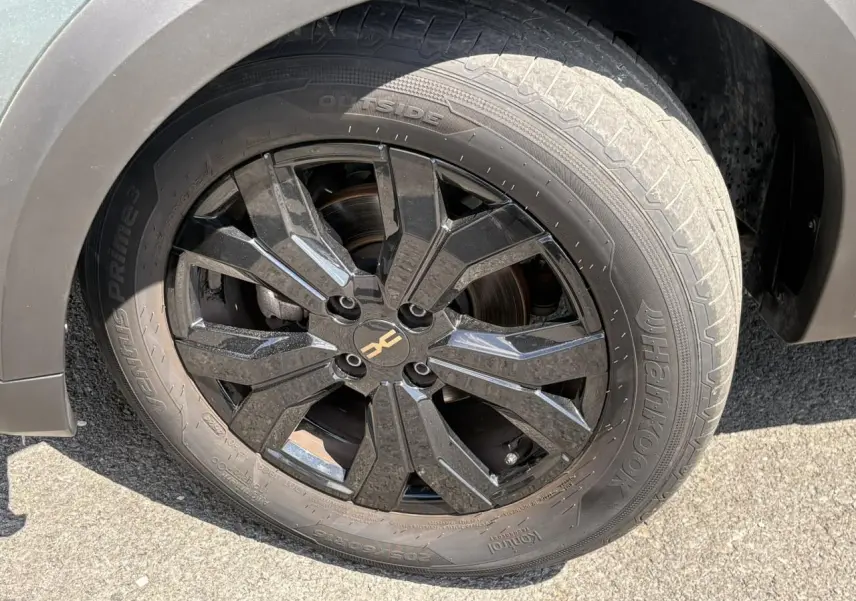 Gros plan sur la jante noire 16" Mahalia avec logo Dacia brun cuivré du Dacia Sandero Stepway Vert Cèdre côté droit.