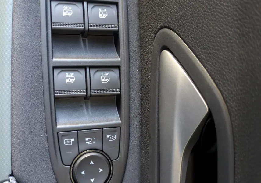 Détail des commandes des vitres et rétroviseurs sur la porte intérieure côté conducteur du Dacia Bigster Hybrid 155 Extreme.