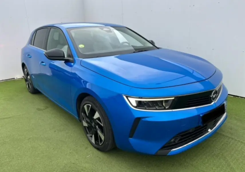 Opel Astra VI bleu clair vue 3/4 avant droit avec jantes alliage noires et calandre moderne noire.