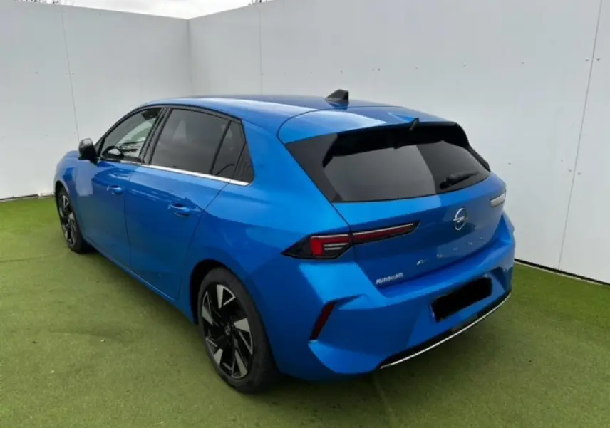 Opel Astra VI diesel bleu clair vue 3/4 arrière droit avec jantes alliage noir et vitres surteintées.