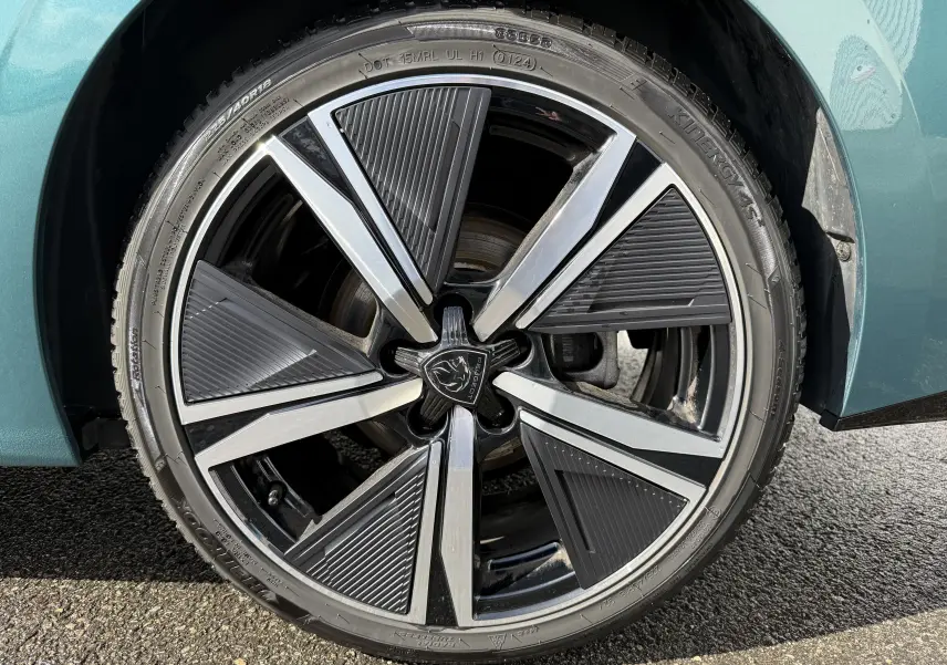 Gros plan sur la jante avant droite de la Peugeot 308 SW BlueHDi 130 EAT8 GT bleu Avatar avec design moderne bicolore.