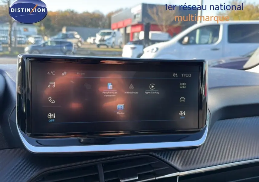Écran tactile central du tableau de bord de la Peugeot 208 1.2 Hybrid 2025, avec interface connectée visible.