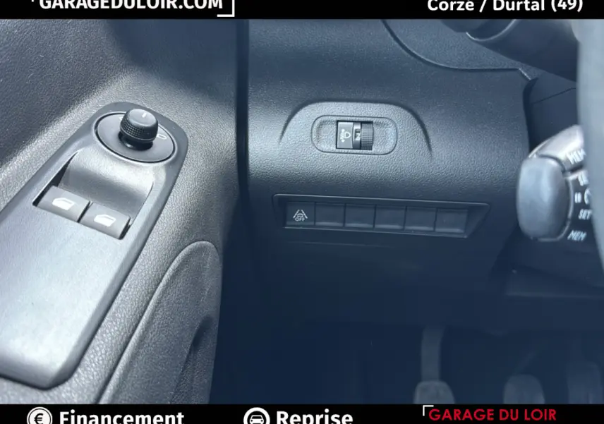 Détail intérieur côté gauche du Peugeot Rifter 2024 bleu, avec commandes des vitres et réglage des phares.