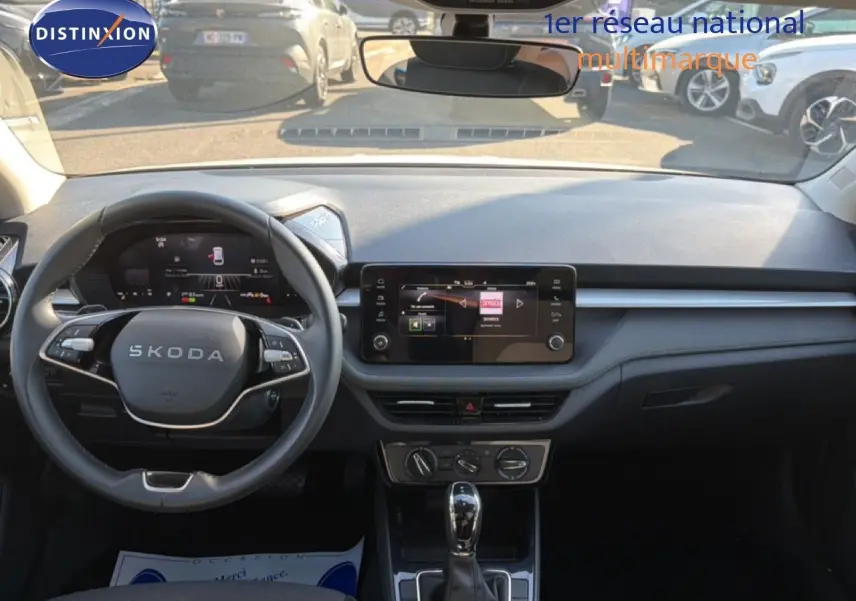 Vue intérieure frontale du tableau de bord et volant noir d'une Skoda Fabia 2025 avec écran tactile central et boîte automatique.