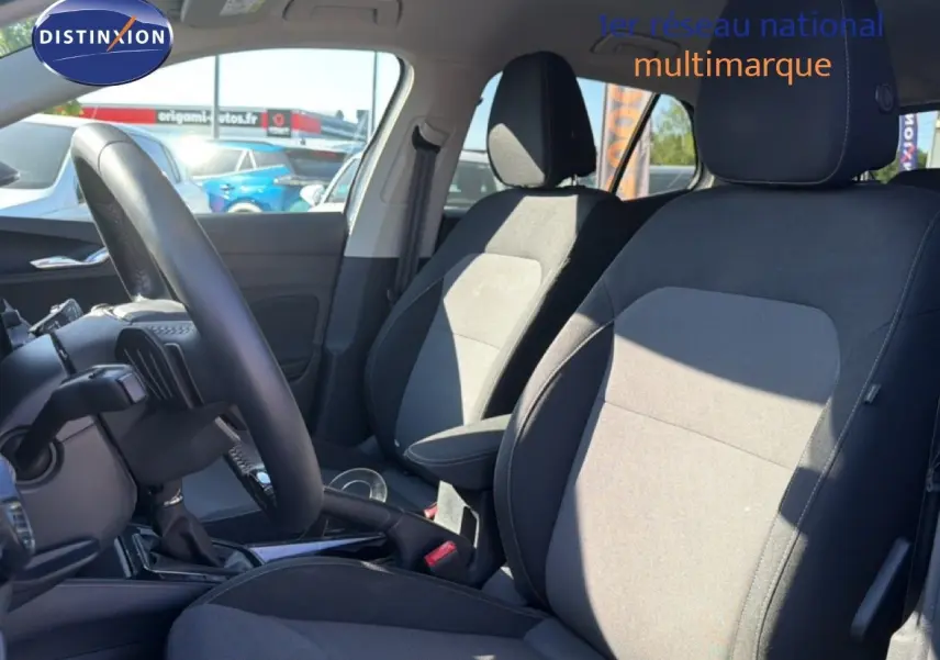 Vue intérieure côté gauche de la Skoda Fabia 2025, sièges tissu noir et gris avec volant cuir multifonction.