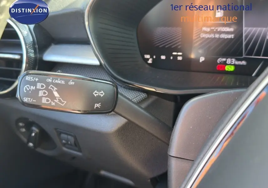 Détail du commodo de régulateur de vitesse dans l'habitacle d'une Skoda Fabia blanc glacier, côté gauche du volant.