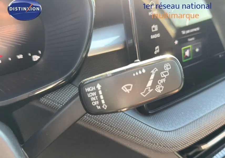 Gros plan sur la commande d’essuie-glace à gauche du volant dans l’habitacle noir d’une Skoda Fabia blanche.