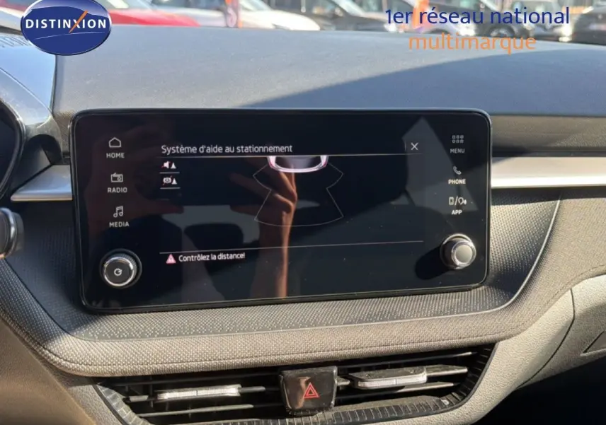 Écran tactile du système d'aide au stationnement dans l'habitacle d'une Skoda Fabia 2025, tableau de bord noir.