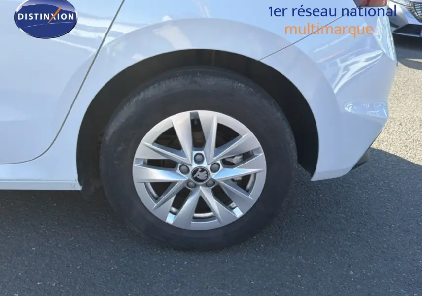 Gros plan sur la roue arrière droite d'une Skoda Fabia blanc glacier, avec jante alliage et partie de la carrosserie visible.