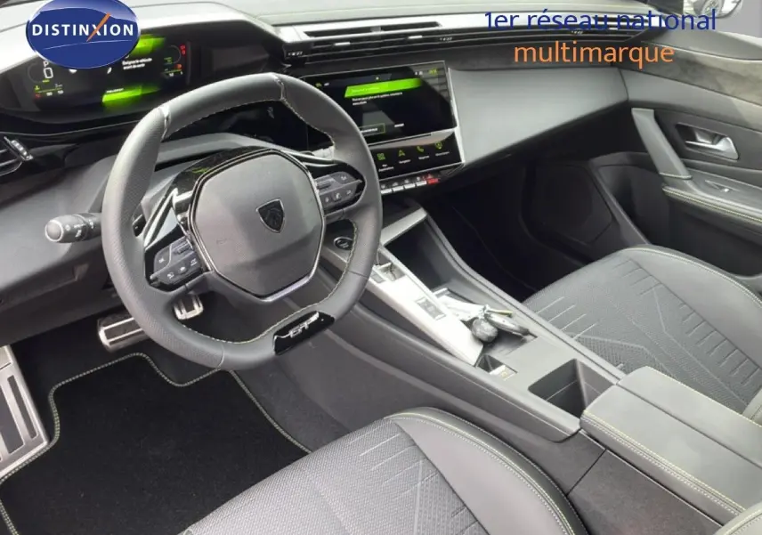 Vue intérieure de la Peugeot 308 1.2 Hybrid 145ch GT montrant le volant cuir, tableau de bord numérique et console centrale moderne.