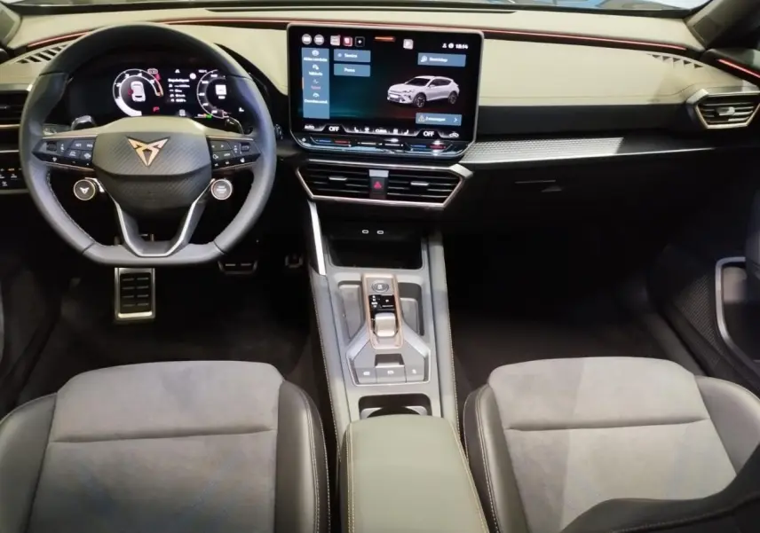 Vue intérieure avant de la CUPRA Formentor 2026, tableau de bord noir avec écran tactile HD et volant Supersports cuir.