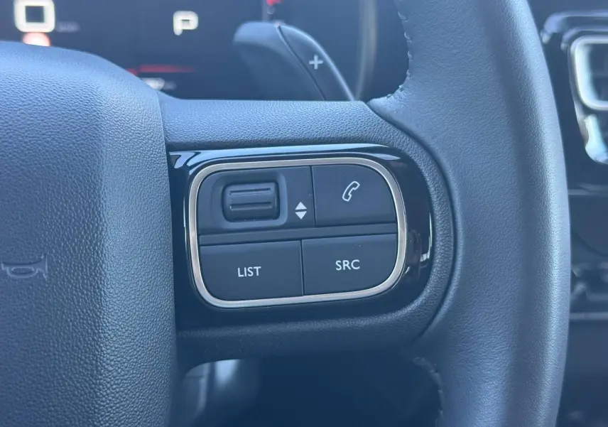 Gros plan sur les commandes gauche du volant noir du Citroën C5 Aircross 2025 avec boutons de gestion audio et appel.