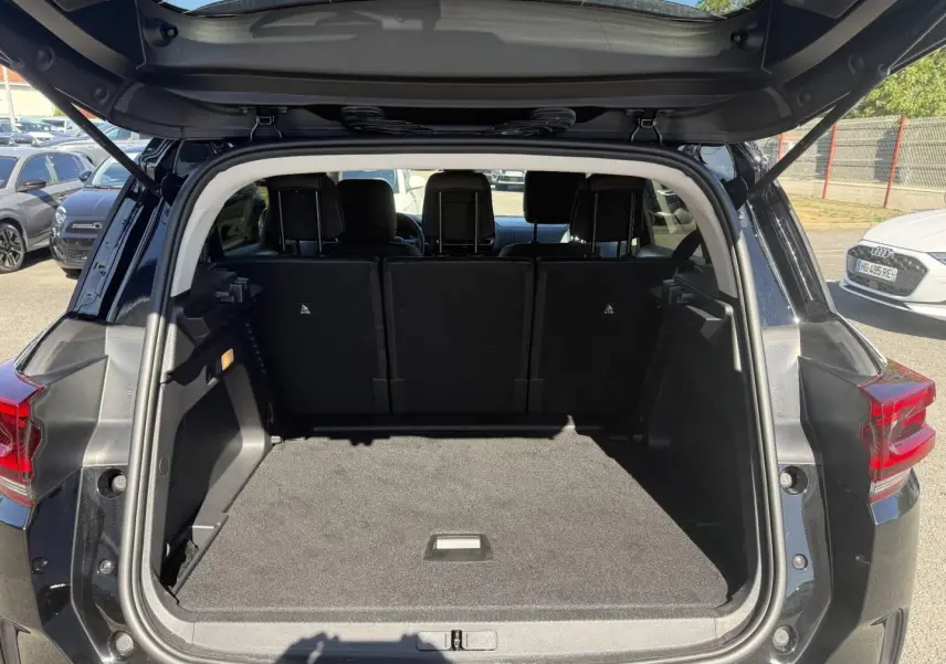 Coffre ouvert vu de l'arrière d'un Citroën C5 Aircross noir Perla Nera avec sièges arrière en place.