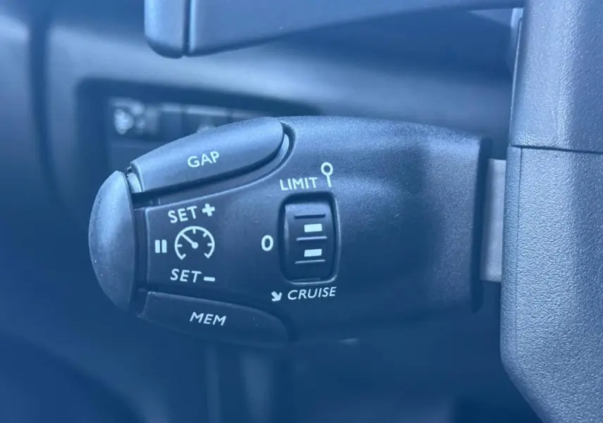 Gros plan sur la commande de régulateur de vitesse et limiteur sur le côté gauche du volant du Citroën C5 Aircross noir.