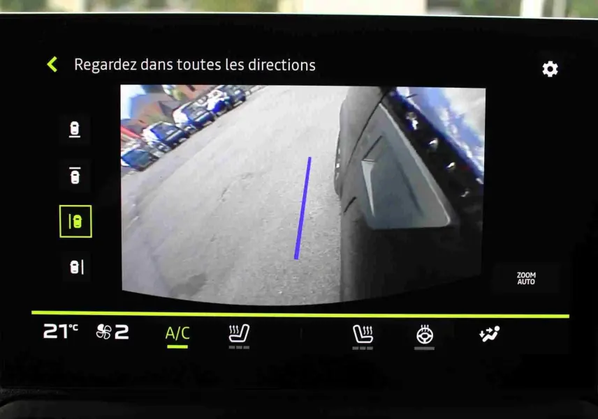 Vue écran caméra 360 du côté droit du Dacia Duster noir nacré, avec ligne guide bleue au sol visible.
