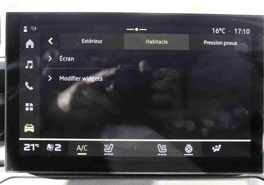Écran tactile central du tableau de bord du Dacia Duster noir, affichant les réglages de l'habitacle et sièges chauffants.