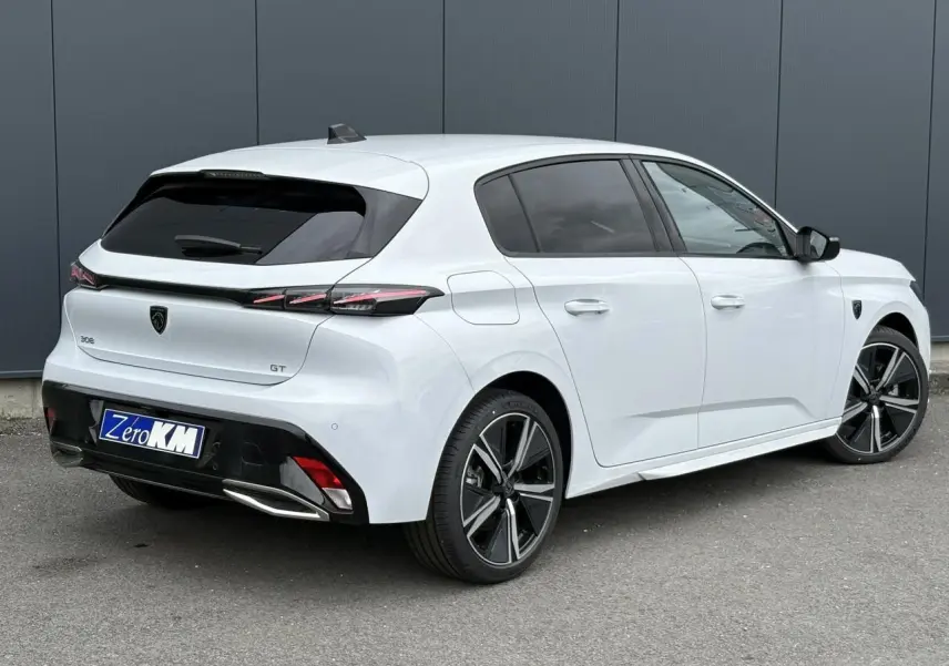 Peugeot 308 GT blanc Okenite vue 3/4 arrière droit, jantes alliage 18'' et feux LED distinctifs.