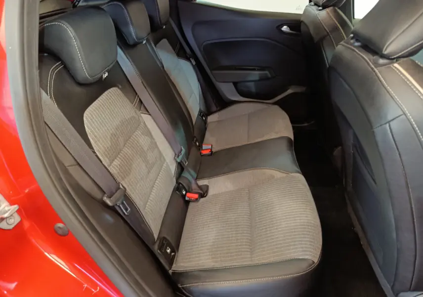 Vue intérieure sur la banquette arrière côté gauche d'une Renault Clio Techno TCe 90 rouge avec sièges bicolores tissu et cuir.