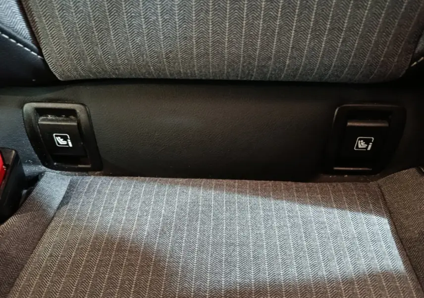 Détail des fixations Isofix sur la banquette arrière en tissu gris de la Renault Clio Techno TCe 90 rouge 2024.