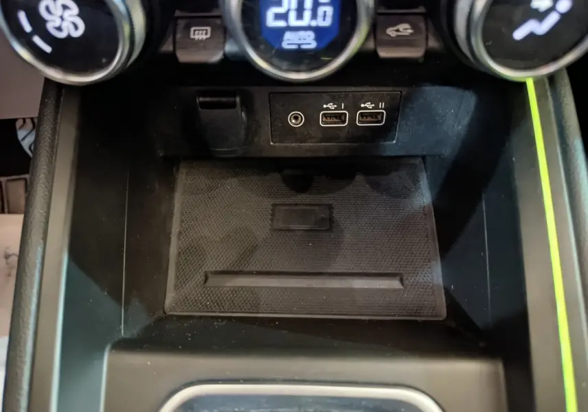 Vue rapprochée de la console centrale noire de la Renault Clio Techno TCe 90 avec ports USB et commandes climatisation.
