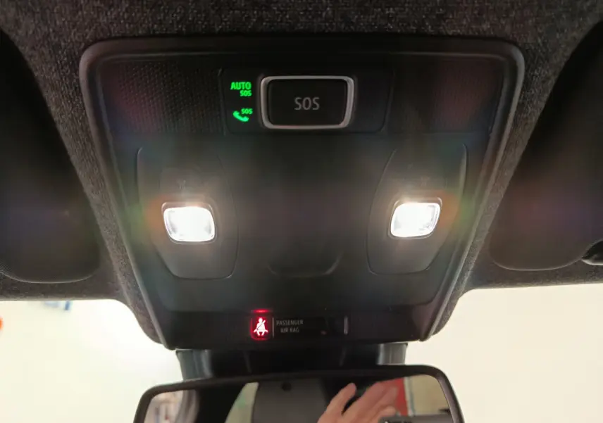 Vue intérieure du plafonnier avec éclairage et bouton SOS actif dans une Renault Clio rouge 2024.