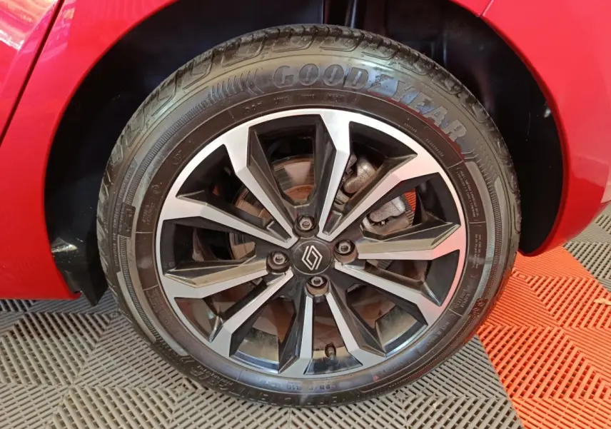 Gros plan sur la roue avant droite rouge de la Renault Clio Techno TCe 90 avec jante alliage noire et argentée.